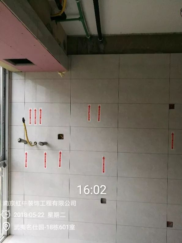 南京武夷名仕園124平米簡美風(fēng)格裝修  享受家?guī)淼臏囟?0五月份_墻磚鋪貼完成后，紅牛裝飾的工人會(huì)用專用護(hù)角條對(duì)瓷磚角保護(hù)，用標(biāo)貼標(biāo)出水管、線管走向示意。